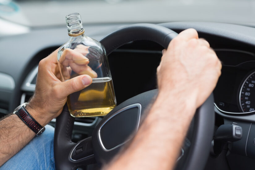 A Man Drinking Alcohol while Driving Photo of a Man Drinking Alcohol while Driving