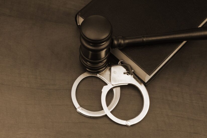 handcuffs with gavel and law book on the table