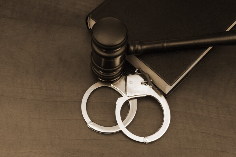 Legal book Legal book with wooden handcuffs and steel handcuffs on the table